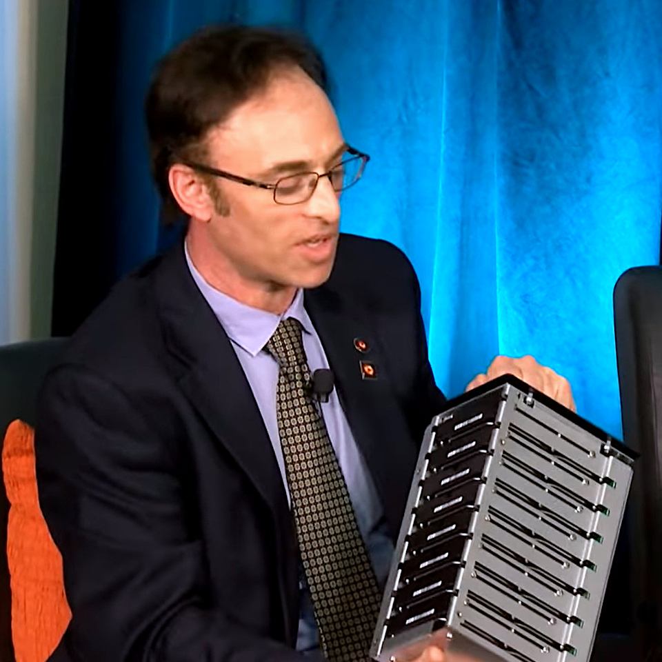 Shep Doeleman, founding director of the Event Horizon Telescope project holding a portable drive bay of 8 hard disk drives like ones used in telescope data collection, May 12, 2022.